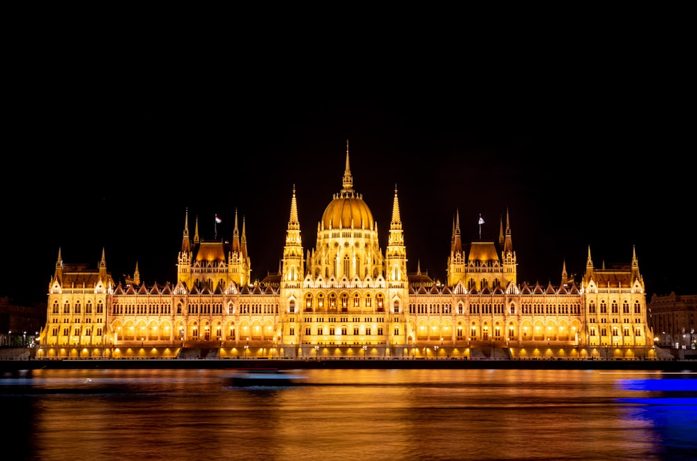 a large building lit up at night on the water