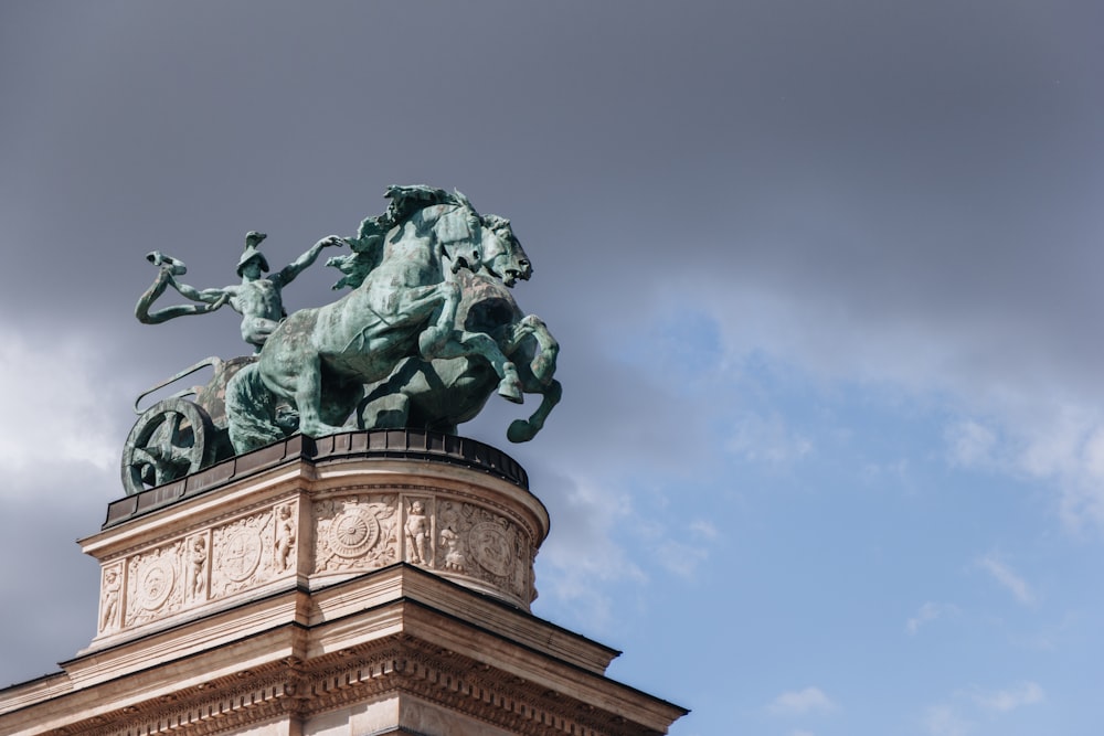 Una estatua de un hombre a caballo en la parte superior de un edificio