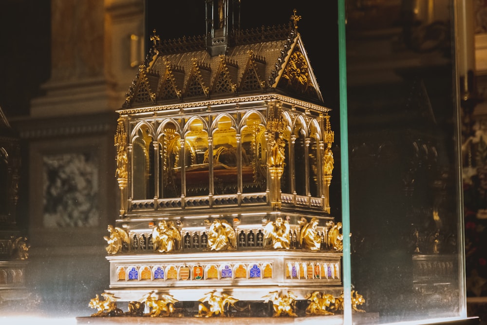 a golden clock on display in a glass case