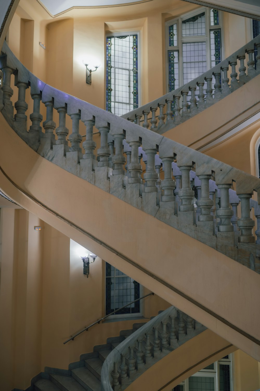 a staircase in a large building with a clock on the wall