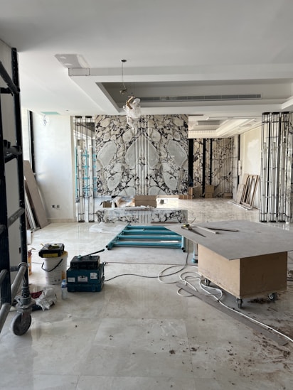 Photo of skilled workers installing marble and electrical systems in a modern interior.