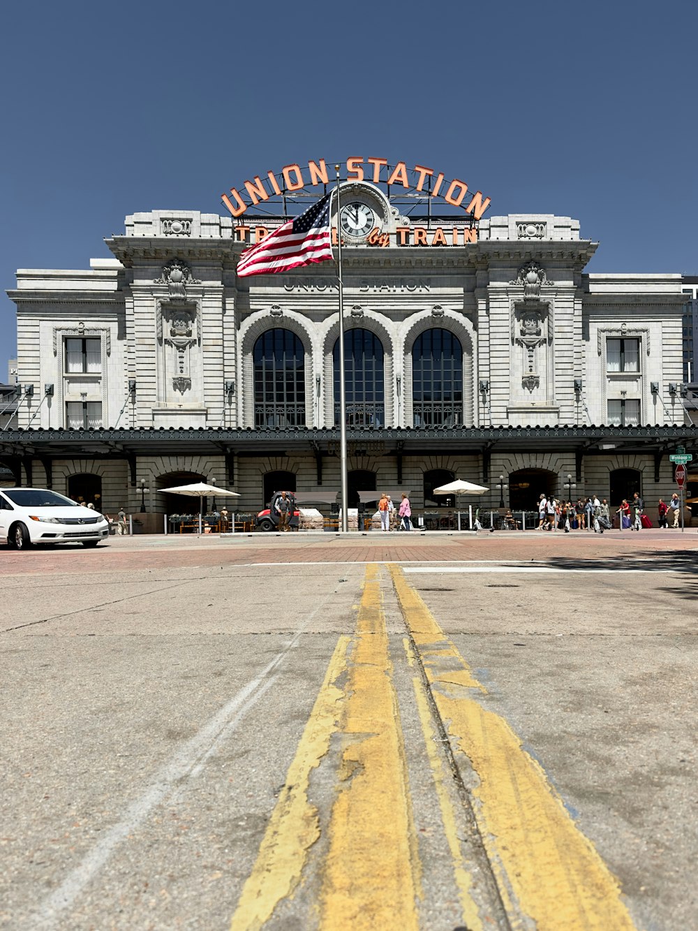 a train station with a yellow line painted on the ground