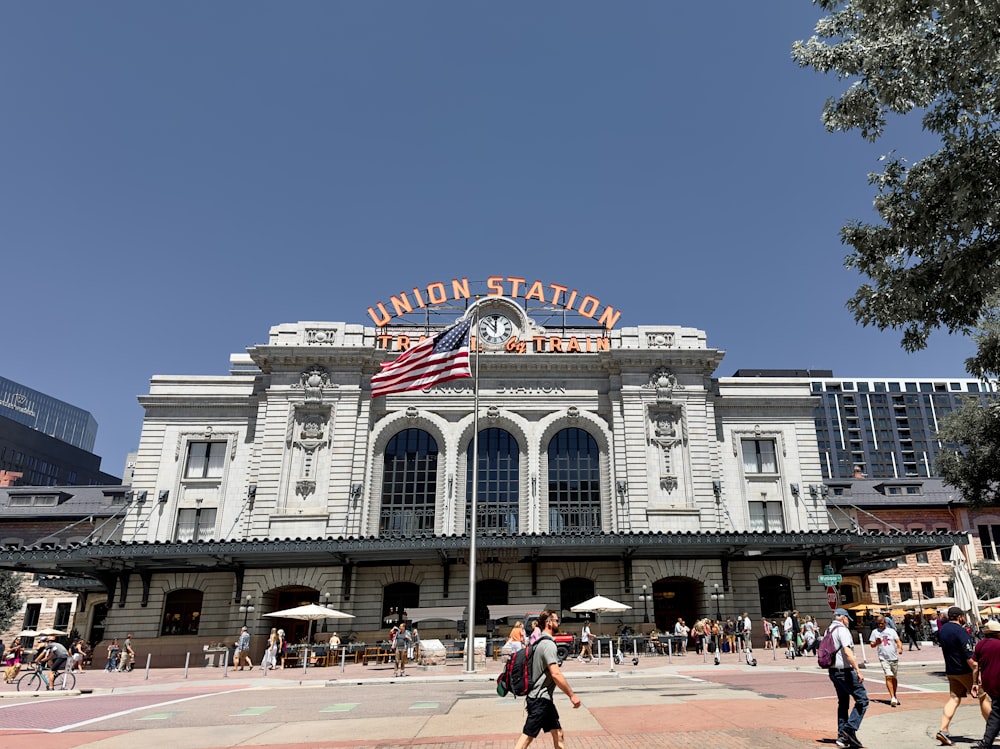 a group of people walking in front of a train station