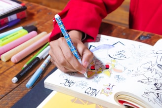 a person is writing on a book with markers