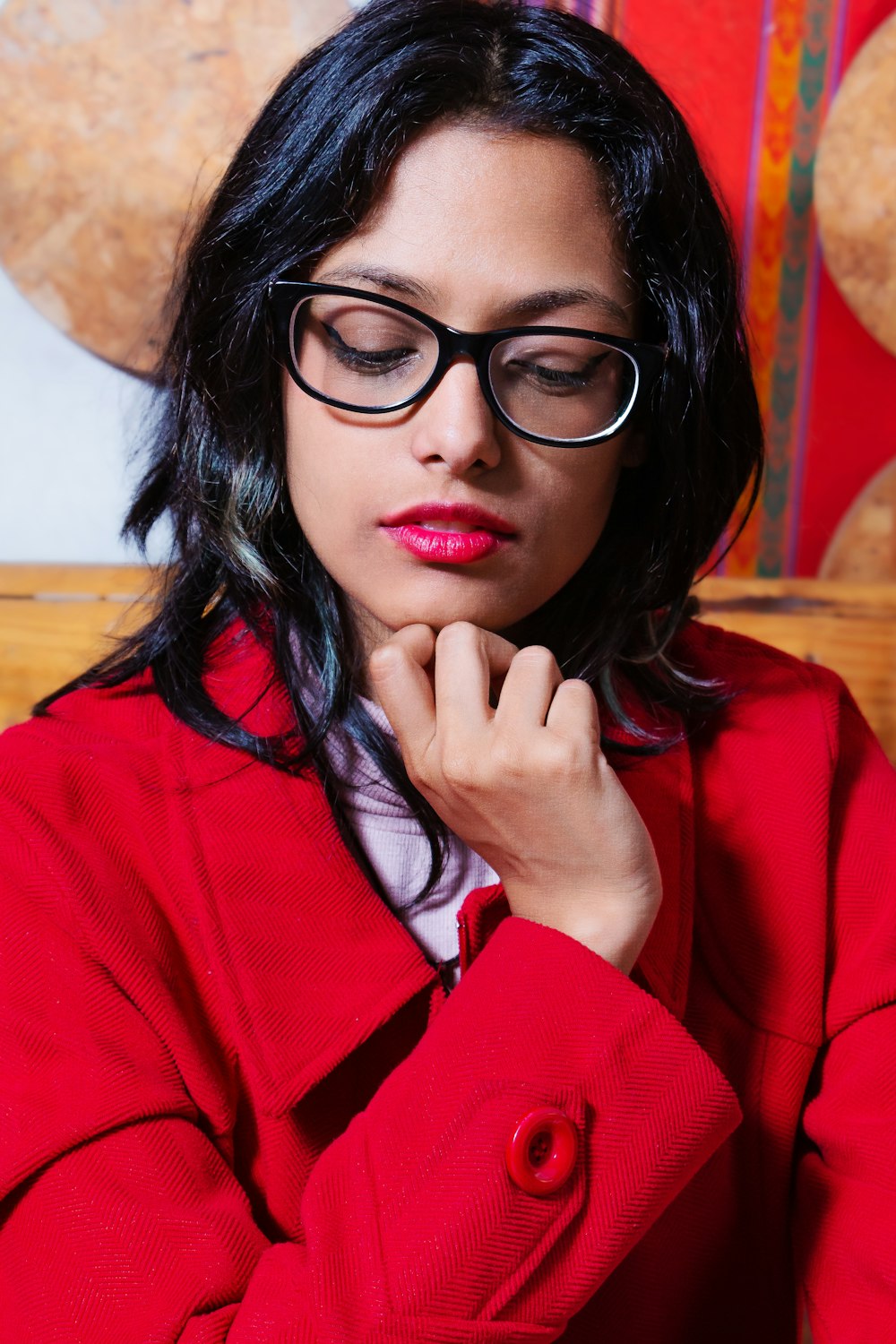 a woman wearing glasses and a red coat