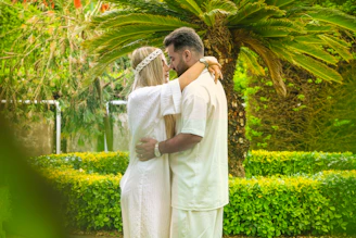 Volunteers warmly embracing a cancer patient amidst a peaceful garden setting.
