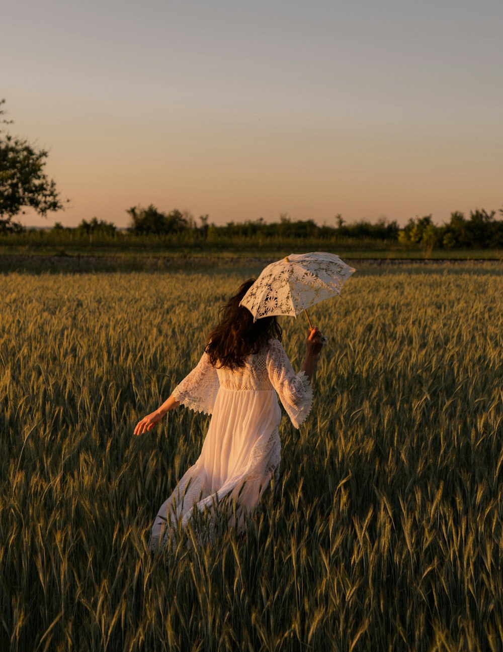 a woman in a field holding an umbrella
