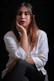 a woman sitting down with her hand on her chin