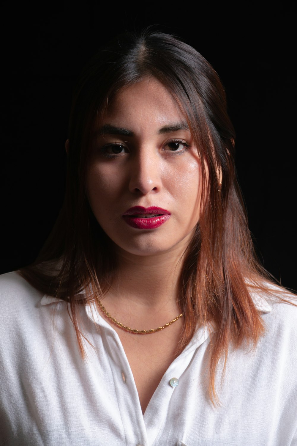 a woman wearing a white shirt and a necklace