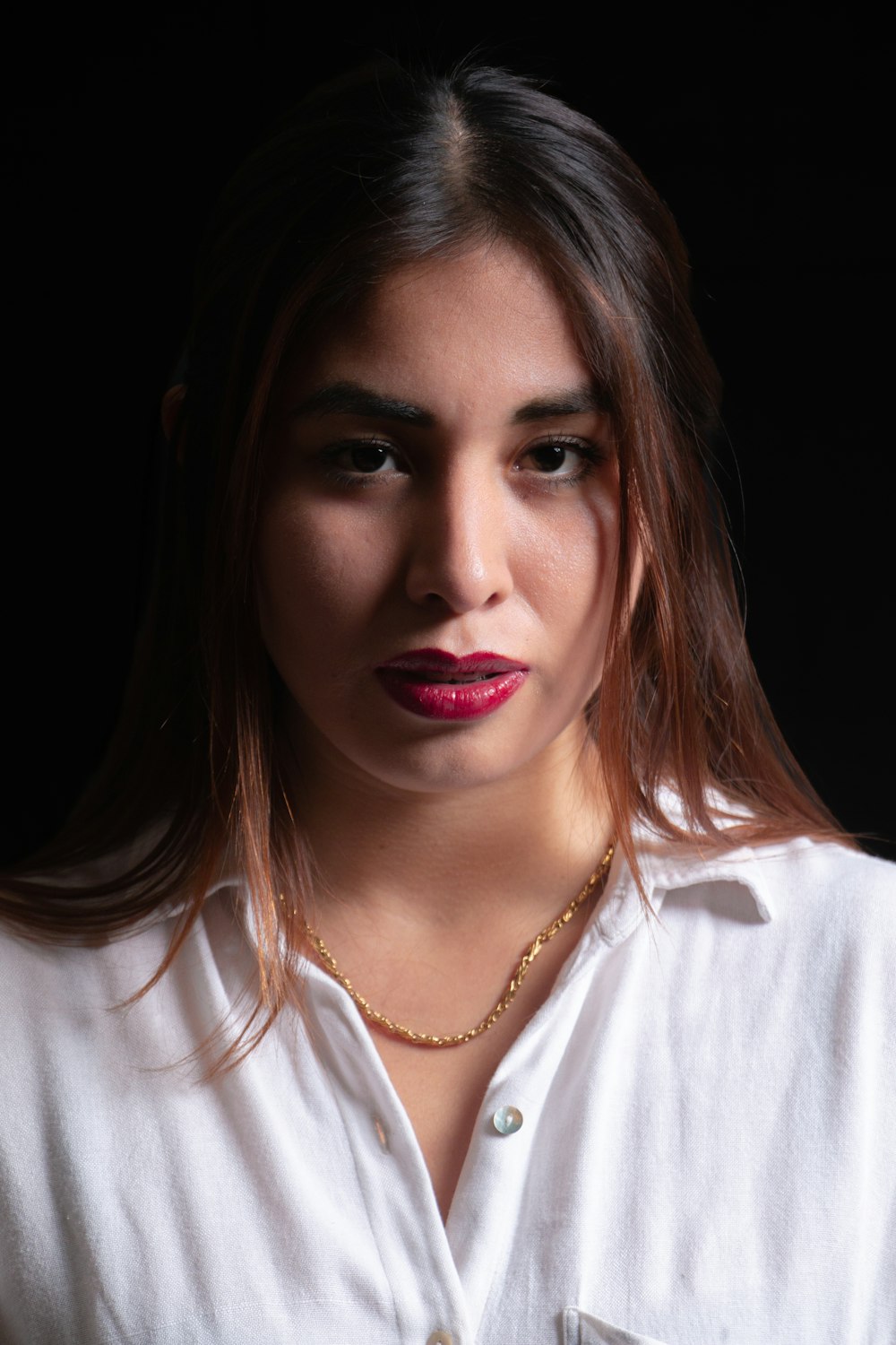 a woman wearing a white shirt and a necklace