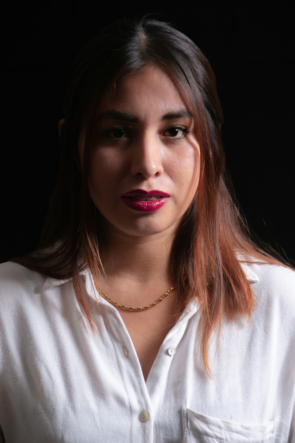 a woman wearing a white shirt and a necklace