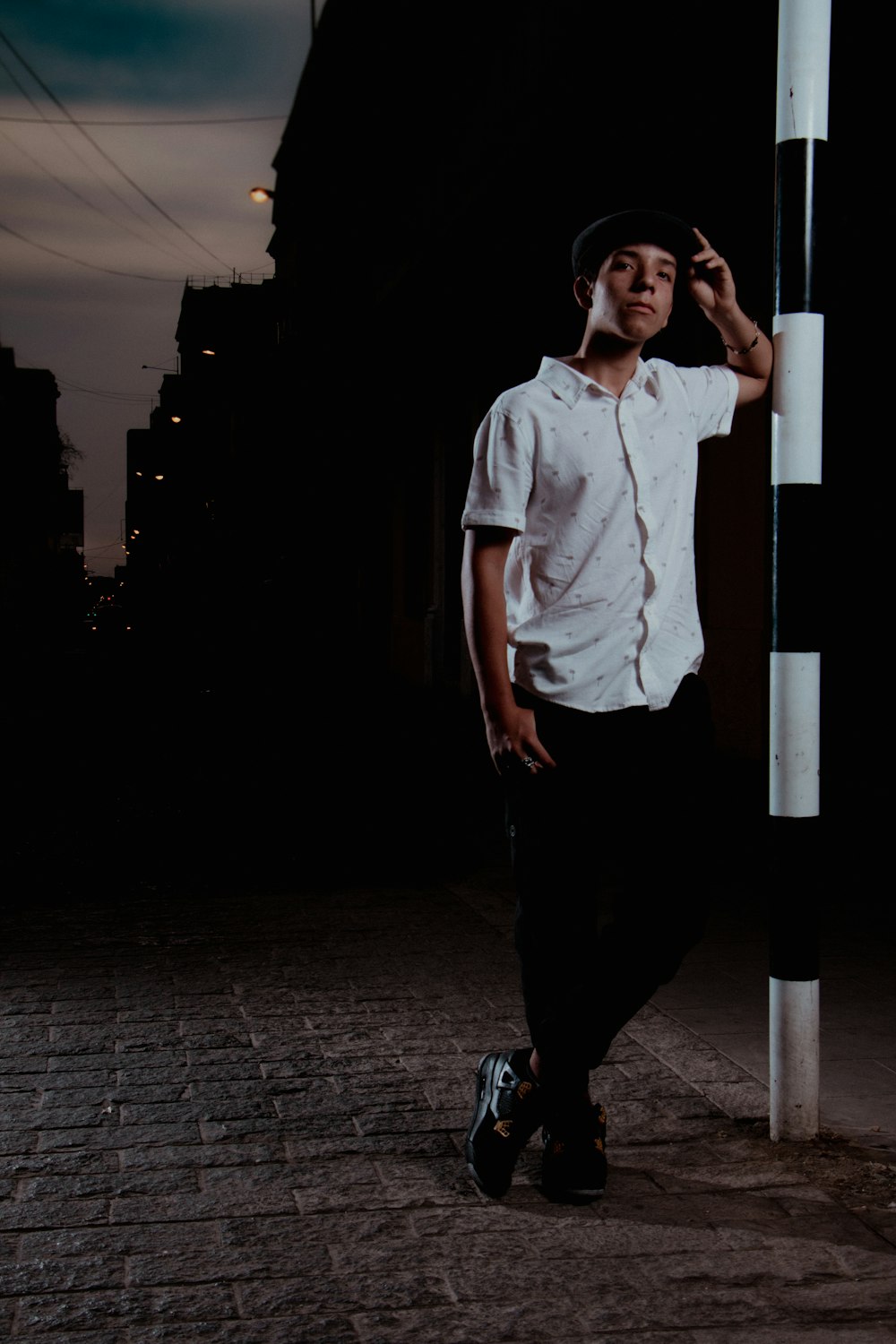 a man standing next to a pole in the dark