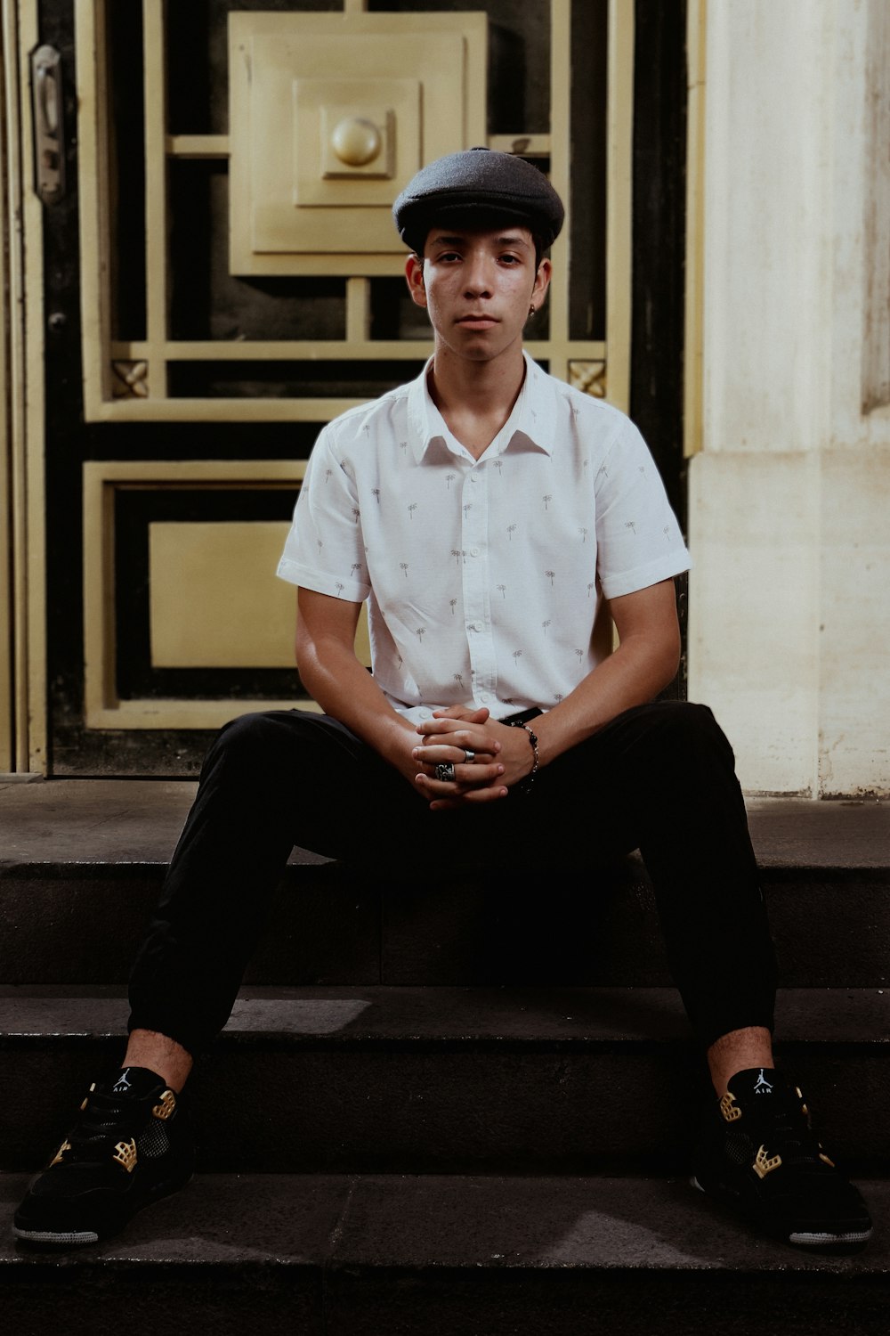a young man sitting on the steps of a building