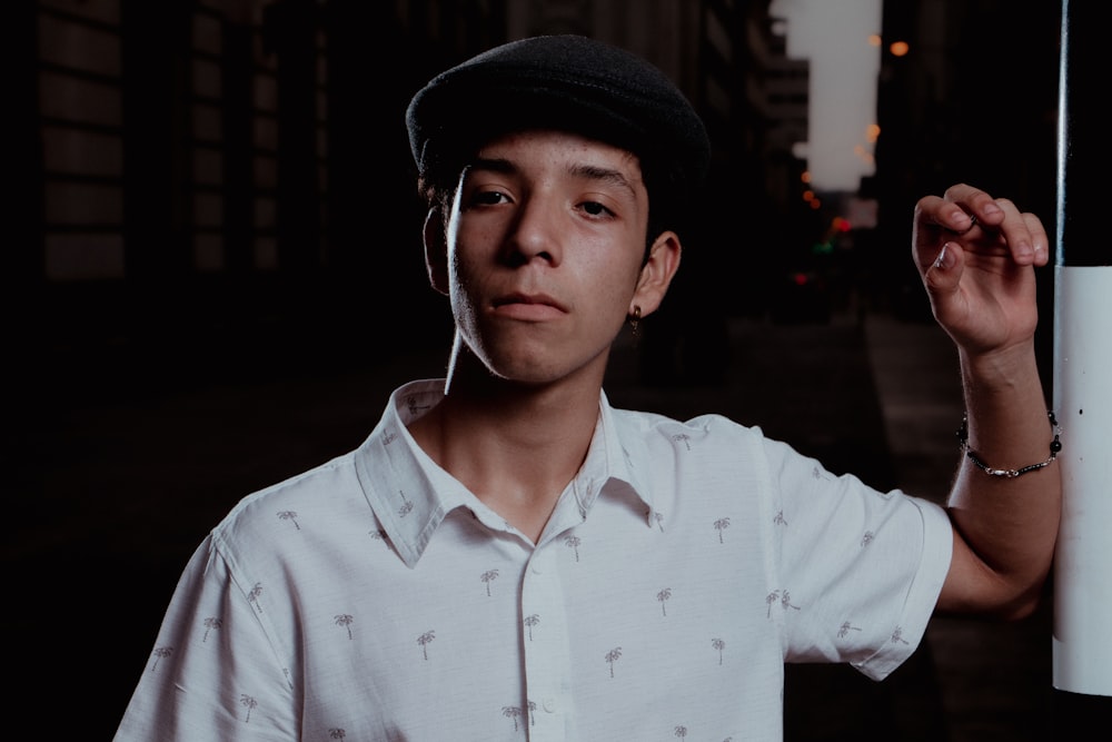 a man in a white shirt and a black hat