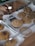 A variety of freshly baked cookies displayed in trays with a hand holding a wooden-handled spatula. The cookies are drizzled with chocolate and have different textures and toppings.