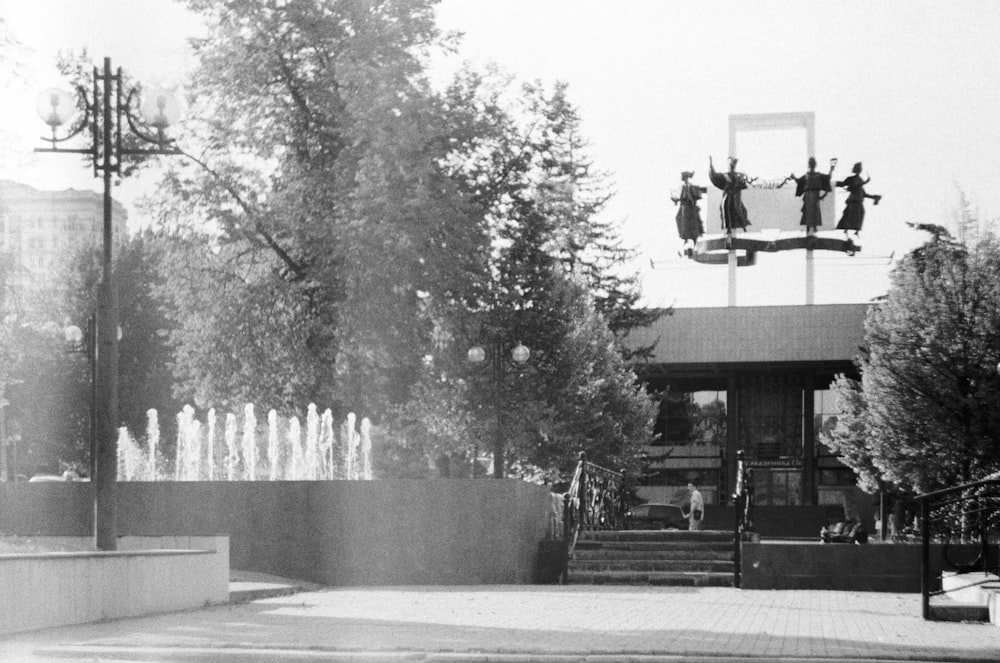 a black and white photo of a building with a fountain