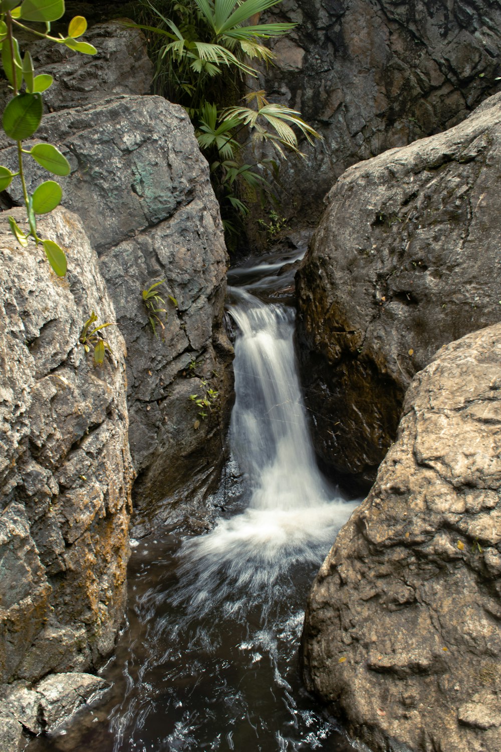 a small waterfall running between two large rocks