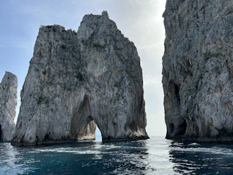 a large rock formation in the middle of a body of water