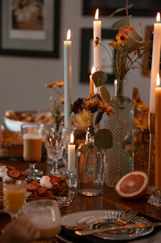 a table is set with candles and plates of food