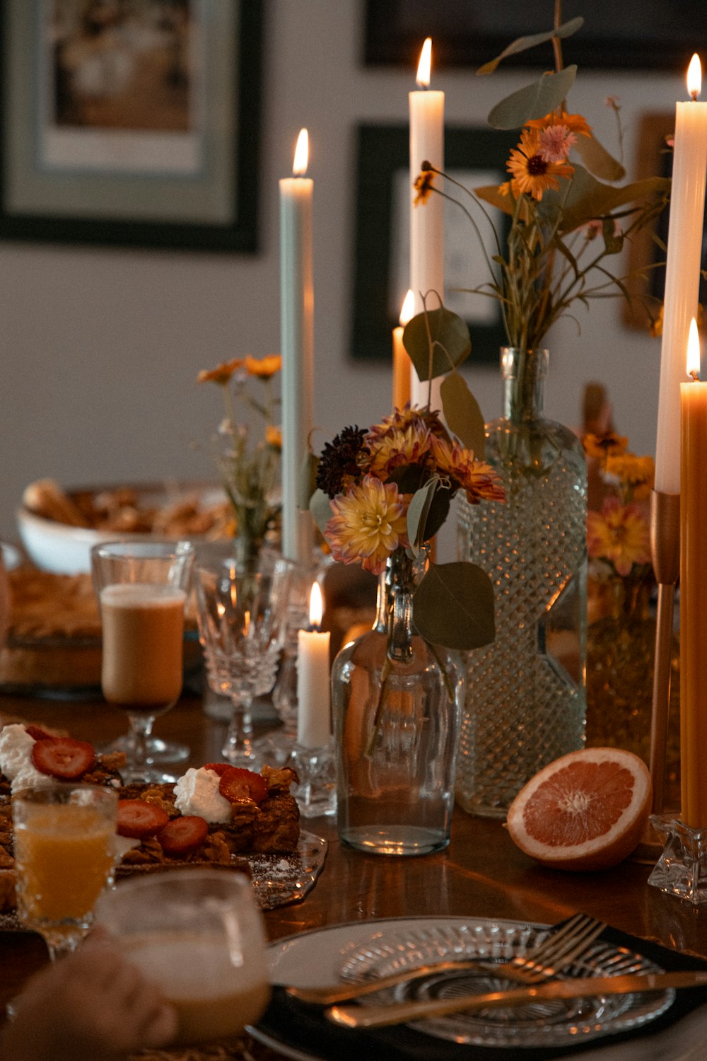 a table is set with candles and plates of food