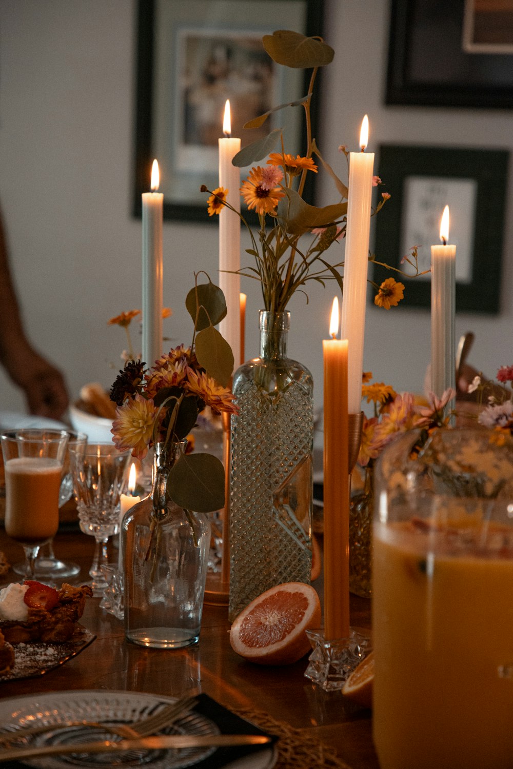 a table topped with a vase filled with flowers and candles
