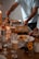 A cozy dining setting with a table filled with elegant dinnerware and a variety of foods. A person is serving food from a casserole dish while another prepares to eat. Decorative elements include candles and small floral arrangements, creating a warm and inviting atmosphere.