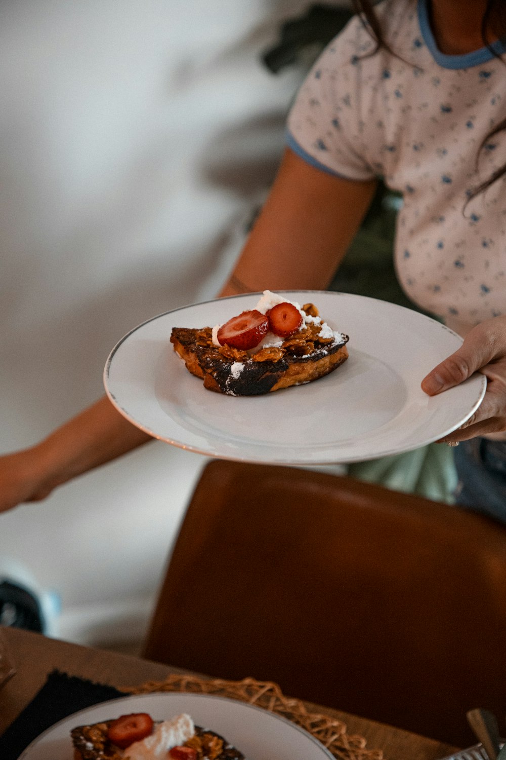 a woman holding a plate with a piece of cake on it