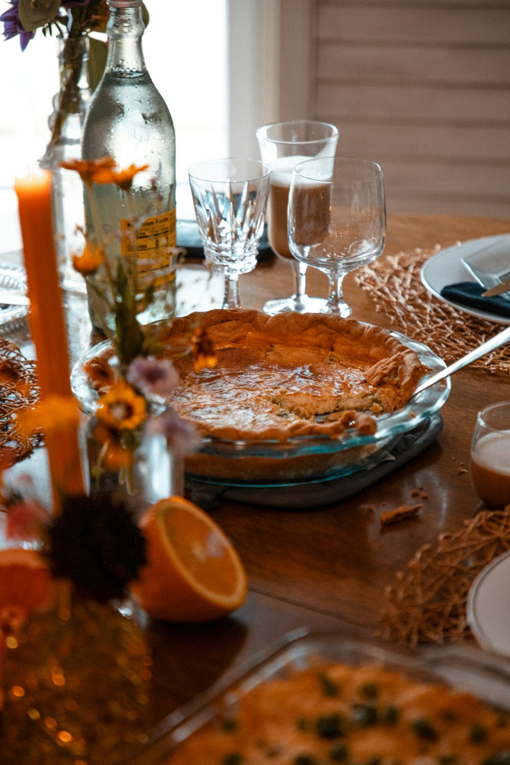 a table is set with plates, silverware, and a bottle of wine