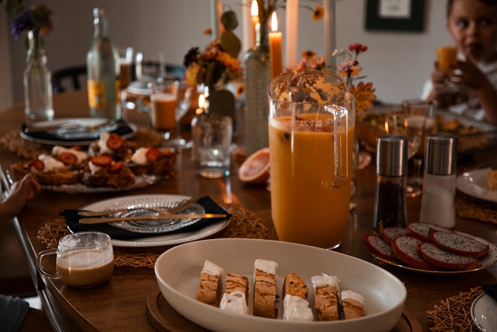 a wooden table topped with plates of food and drinks