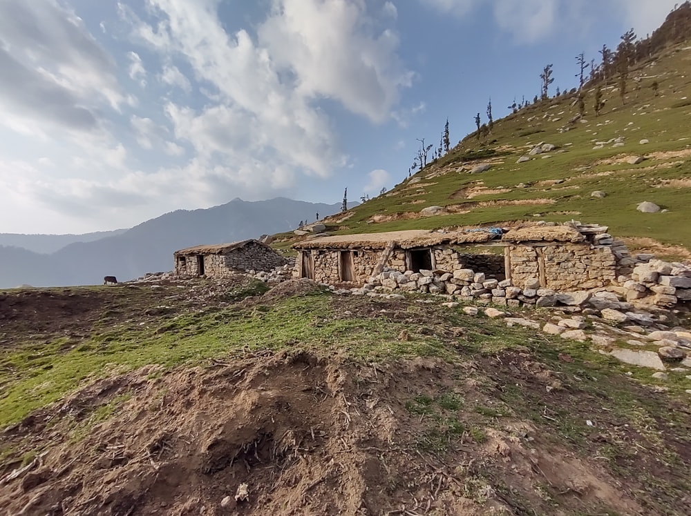 a stone building sitting on top of a lush green hillside