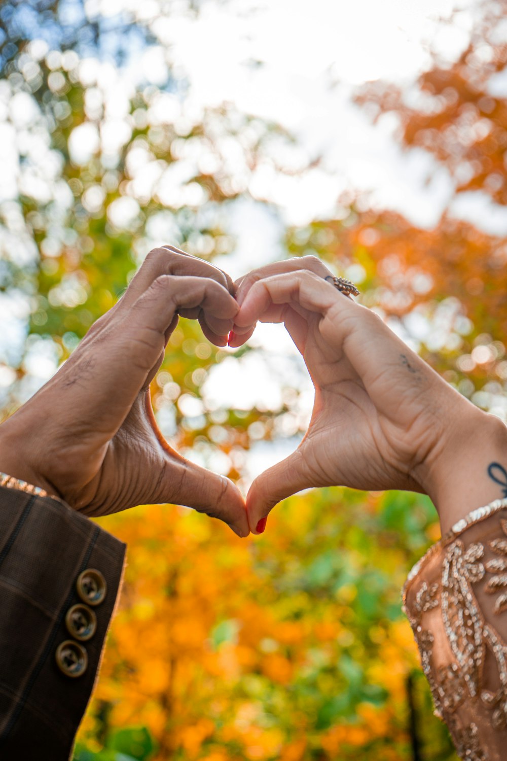 two people making a heart shape with their hands
