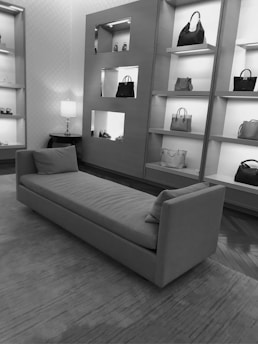 a black and white photo of a couch in a store
