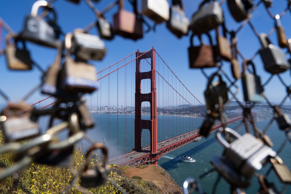 a view of the golden gate bridge through a chain link fence