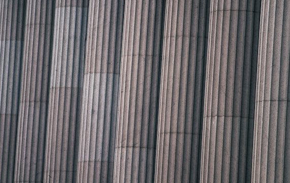 Close-up of carbon fiber material being applied to a building column for reinforcement.