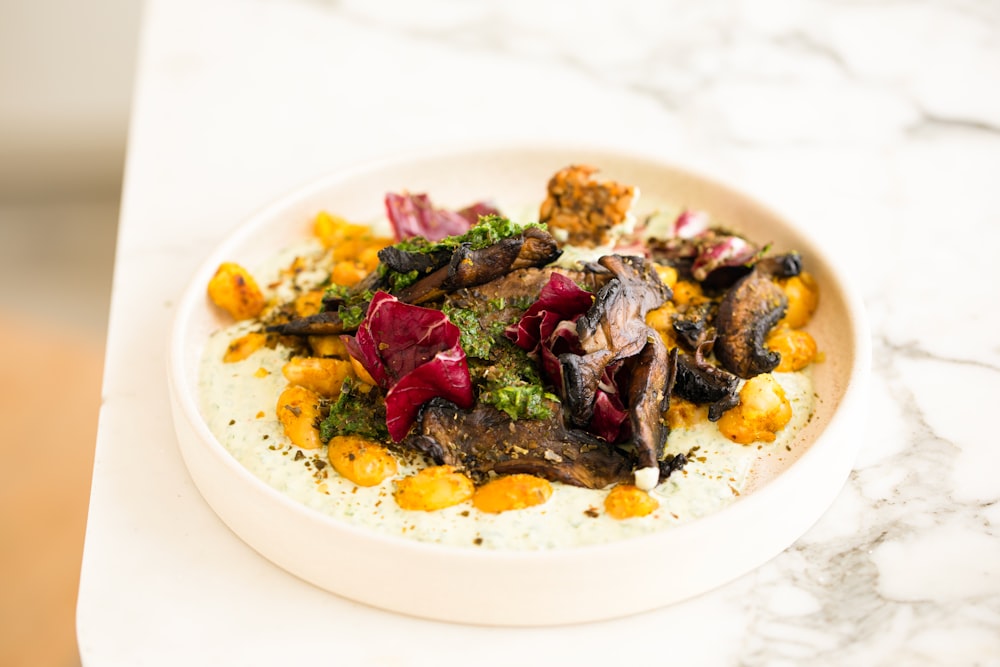 a white bowl filled with food on top of a table