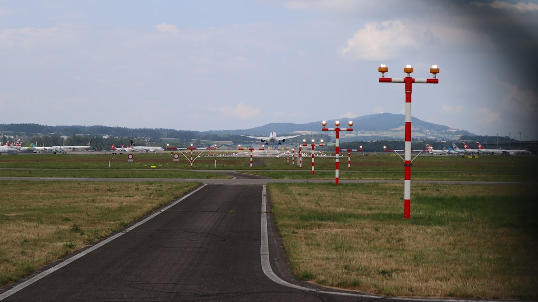 a runway with a bunch of red and white poles, Flugzeuge bei der Landung am ZRH