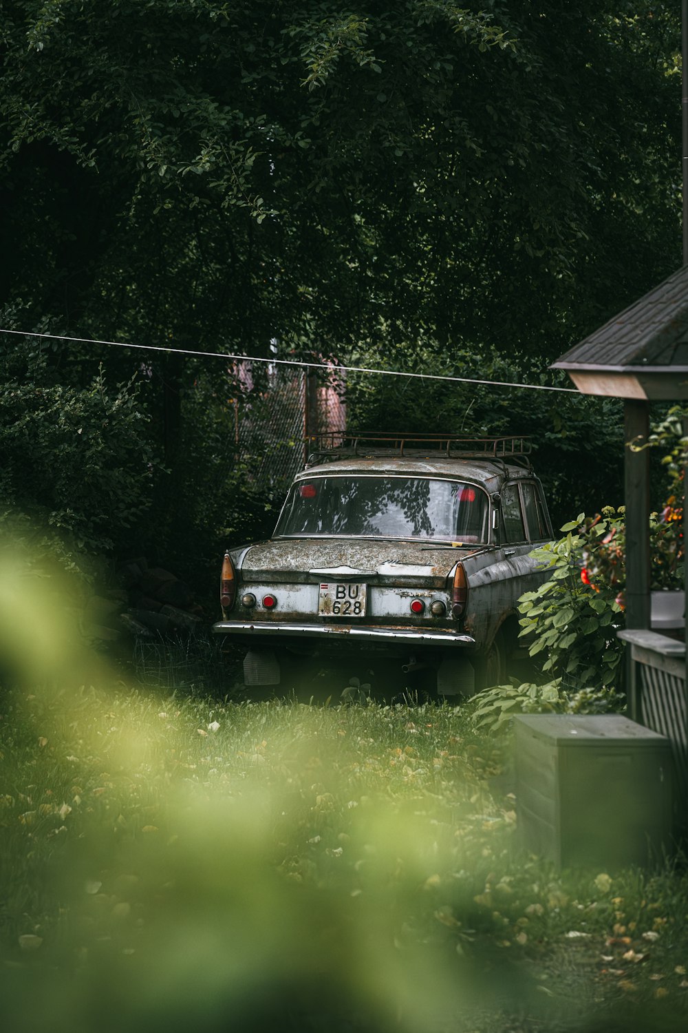 an old car is parked in the yard