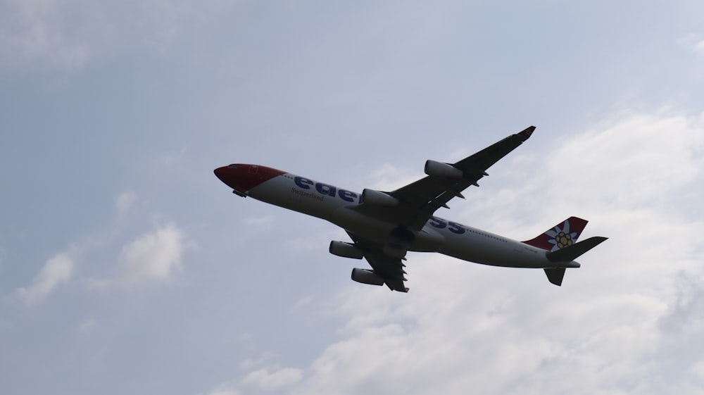 a large jetliner flying through a cloudy blue sky