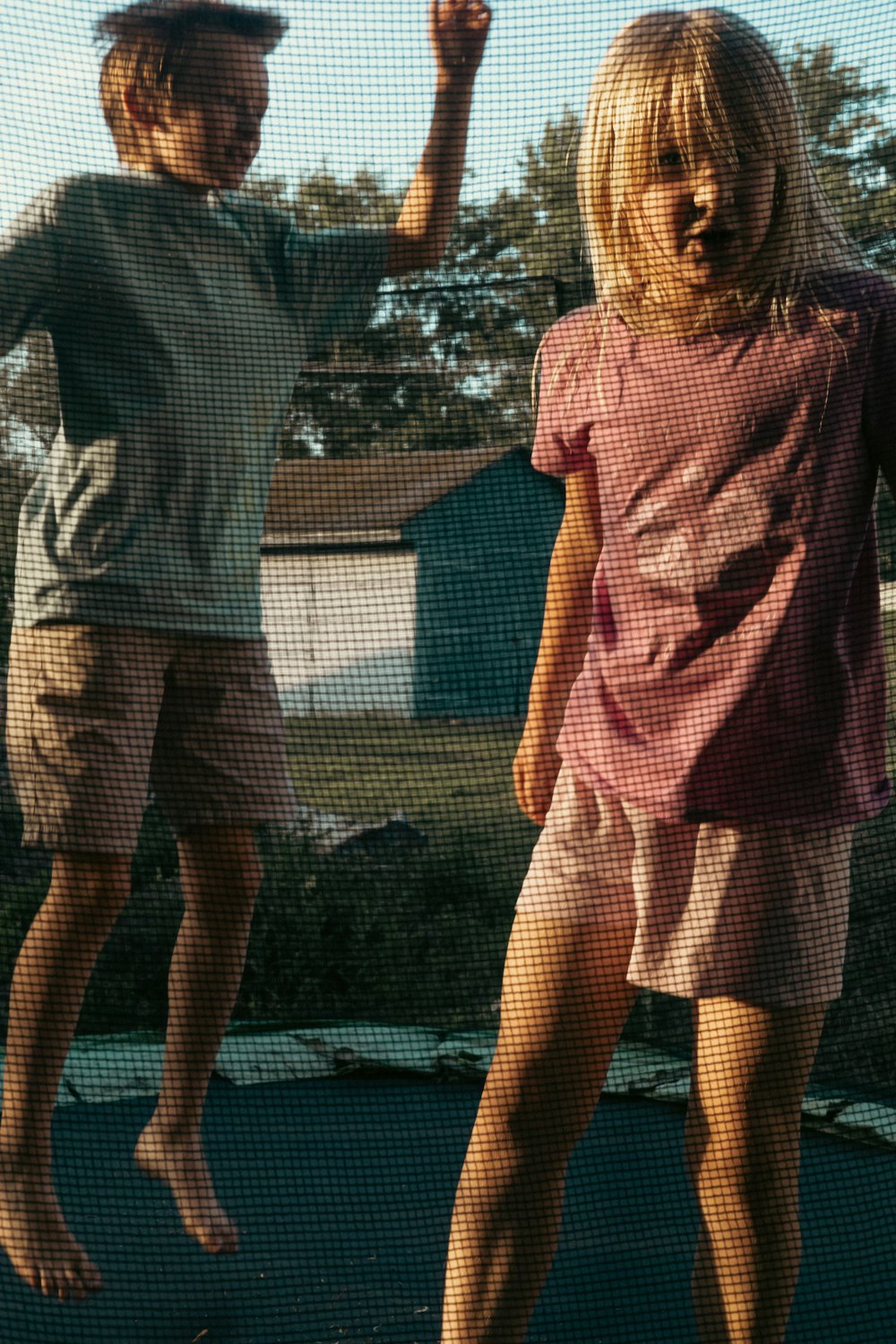 a couple of people that are standing on a trampoline