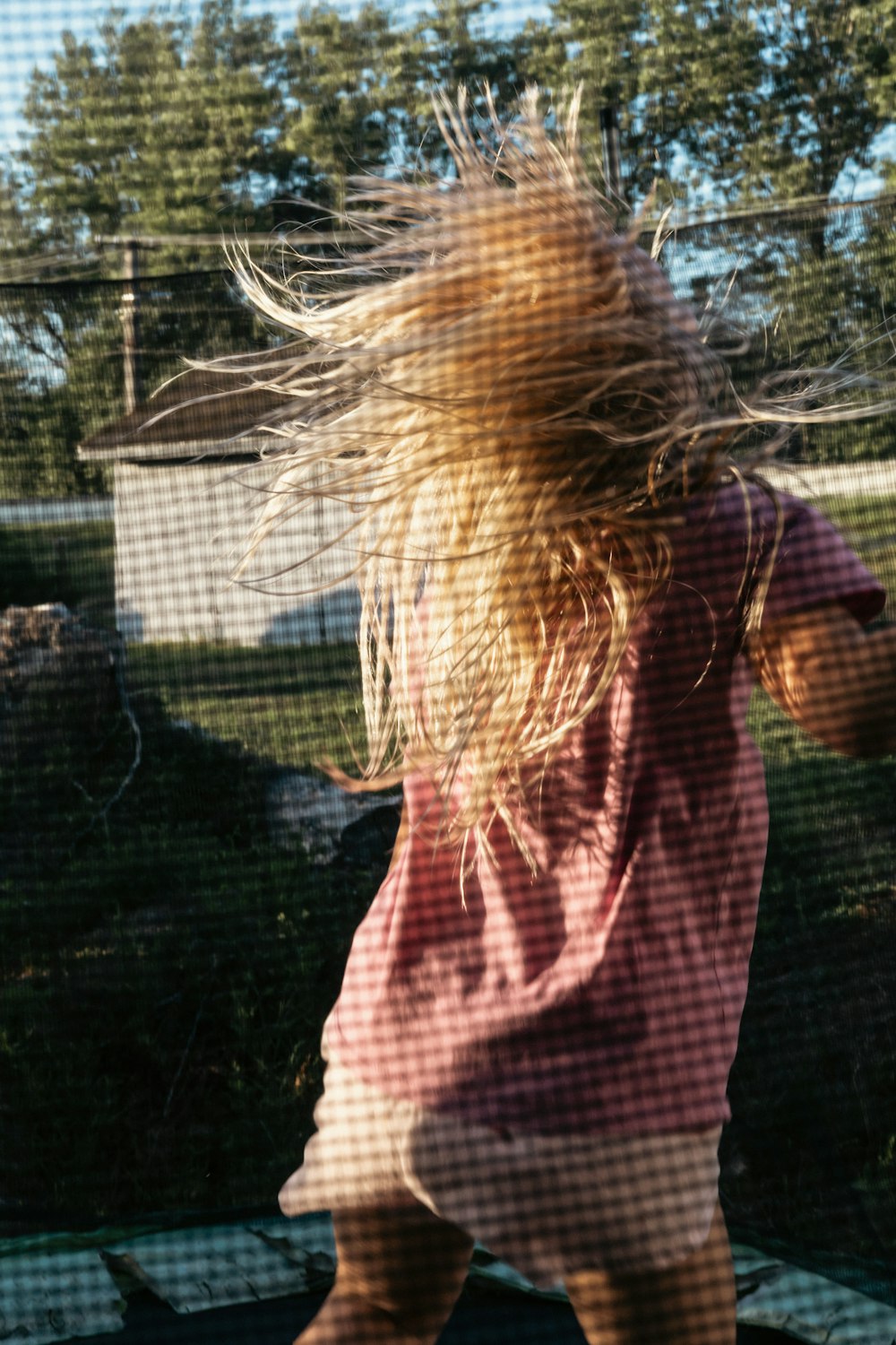 a little girl that is standing on a trampoline