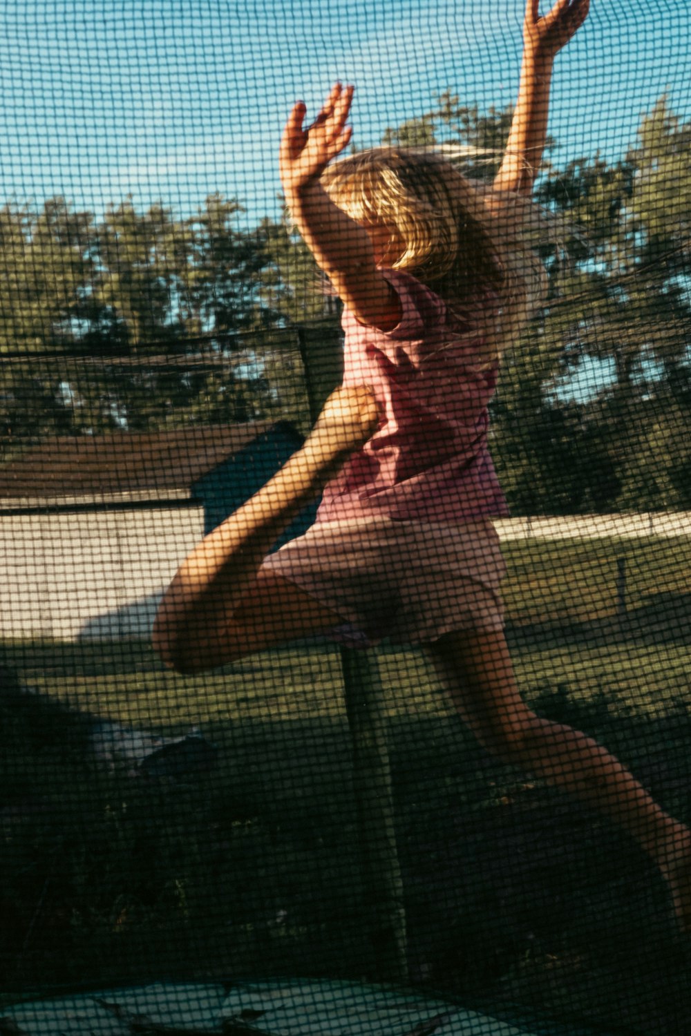 a little girl jumping up into the air to catch a frisbee