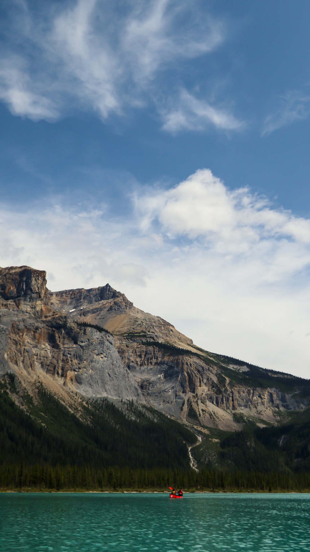 Una barca che galleggia sulla cima di un lago vicino a una montagna