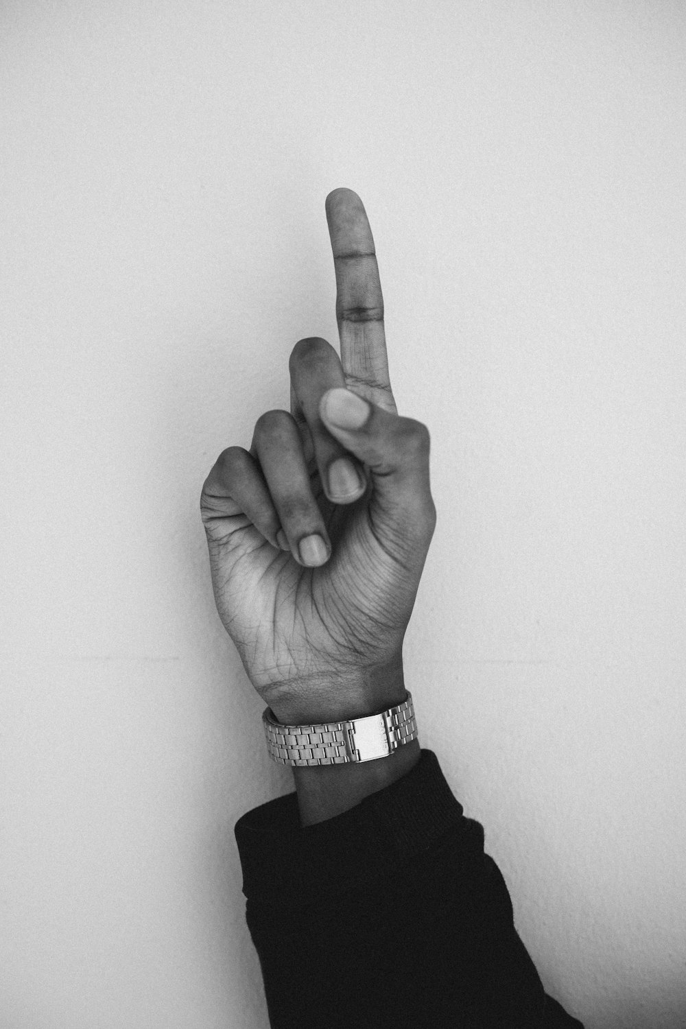 a black and white photo of a person's hand making the v sign