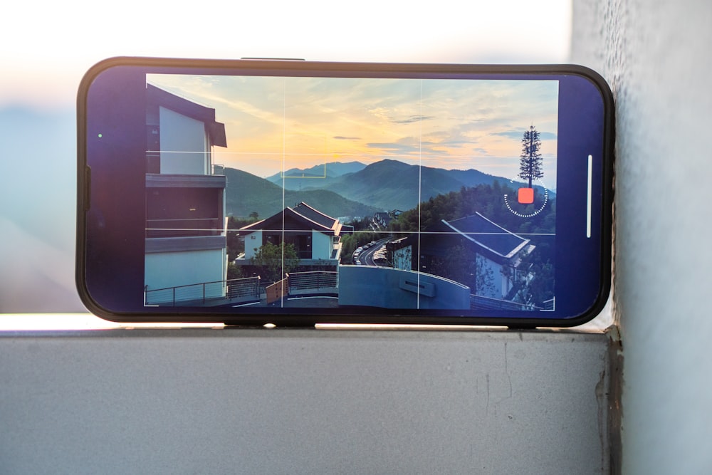 a cell phone with a picture of a house on the screen