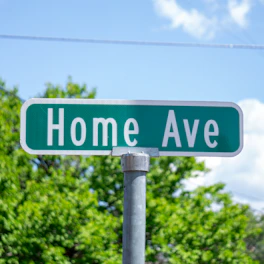 a close up of a street sign with trees in the background