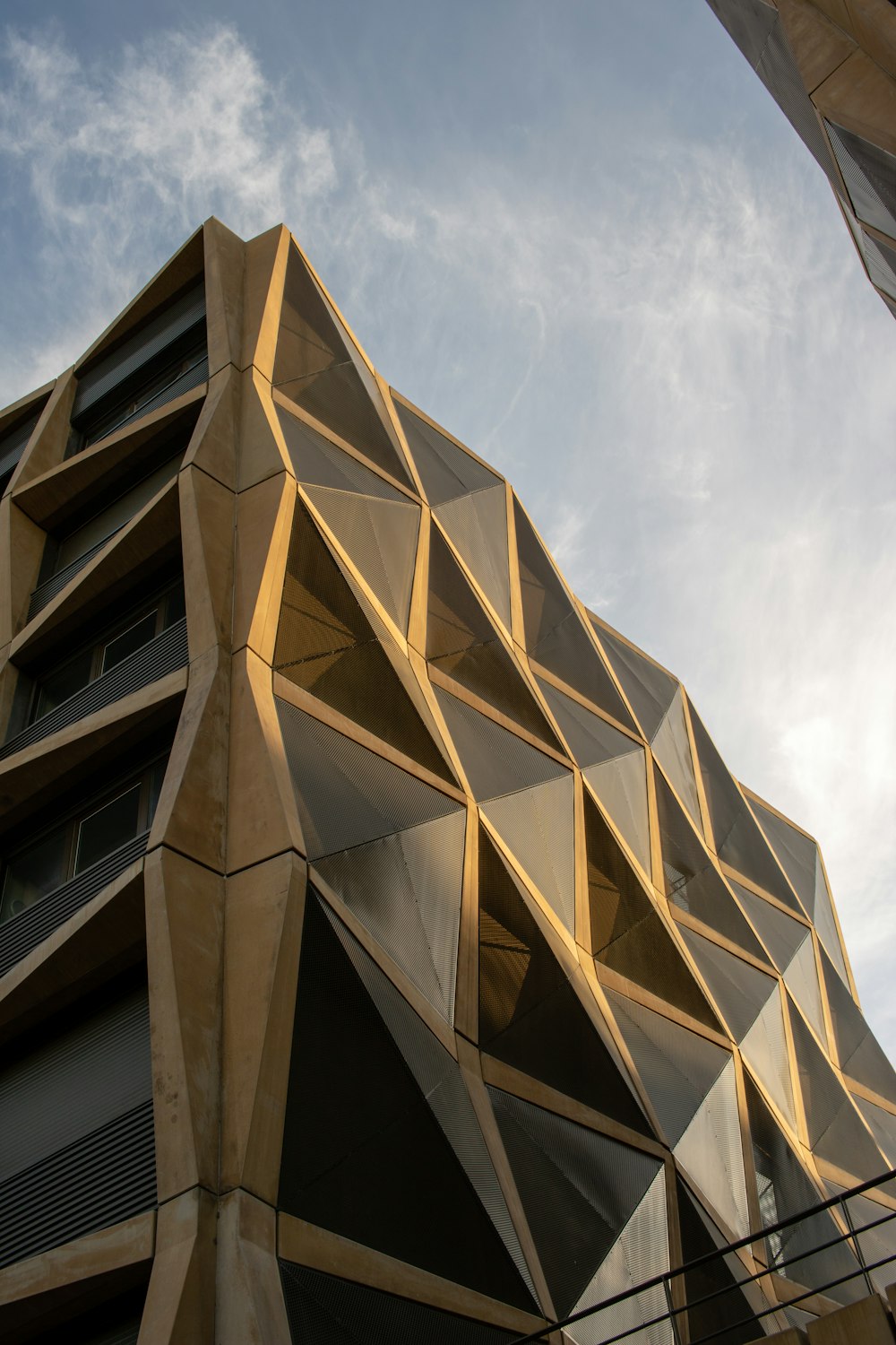 a tall building with many windows and a sky background