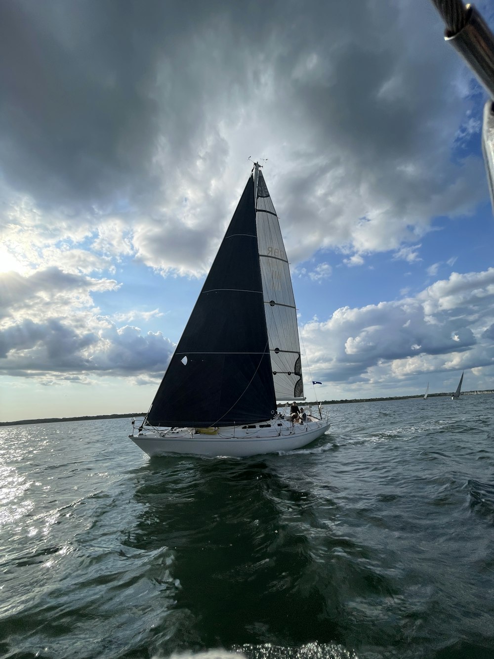 a sailboat sailing on the ocean under a cloudy sky