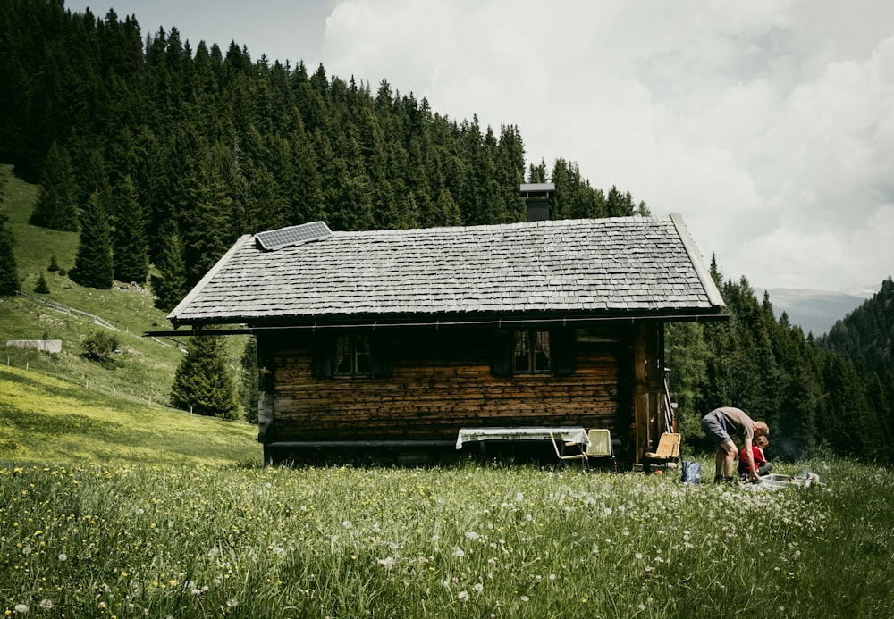 a couple of people standing in front of a wooden cabin