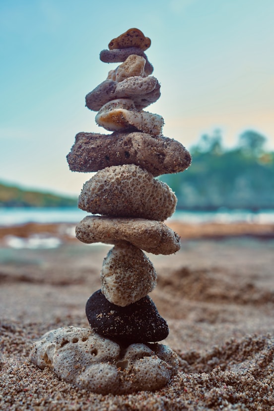 a stack of rocks sitting on top of a sandy beach