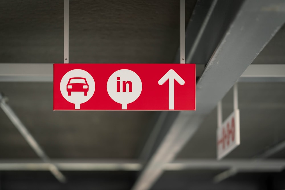 a red sign hanging from the ceiling of a parking garage